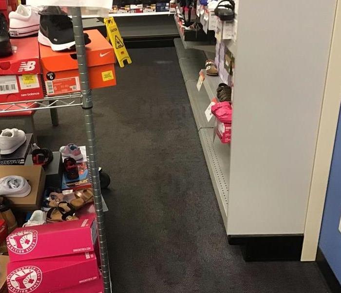 A sales floor in a shoe store that shows wet carpet